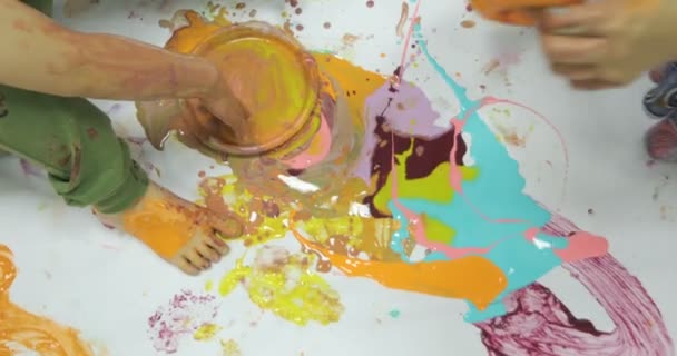 Child being busy covering her body with colorful paint — Stock Video