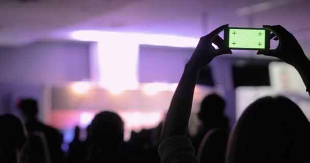 Человек, снимающий видео и фотографии на мобильном смартфоне на конференции. Зеленый экран с люминесцентным матовым покрытием. Концепция проведения семинаров для деловых людей — стоковое видео