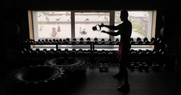 Silueta de hombre atlético haciendo ejercicio con mancuernas gimnasio fondo negro, hombre con mancuernas. Aptitud . — Vídeos de Stock