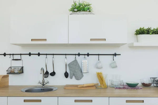 Parlak mutfak arka plan. Parlak beyaz mutfak. Ahşap mutfak tezgahı, şık minimalist mutfak ve yemek alanı iç görünüm. Hiçbir insan.