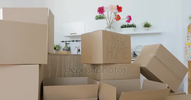 Распаковываем коробки в новом доме и кладем вещи на кухню, большие картонные коробки в новом доме. Переезд на новую концепцию квартиры — стоковое видео