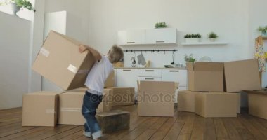 çocuk anne hamle ile yeni bir daireye yardımcı olur, Bebek kutuları taşır. Yeni bir daire kavram taşıma