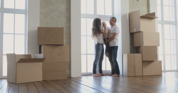 Молода сім'я переїжджає в новий будинок. розслабляється після прибирання і розпакування — стокове відео