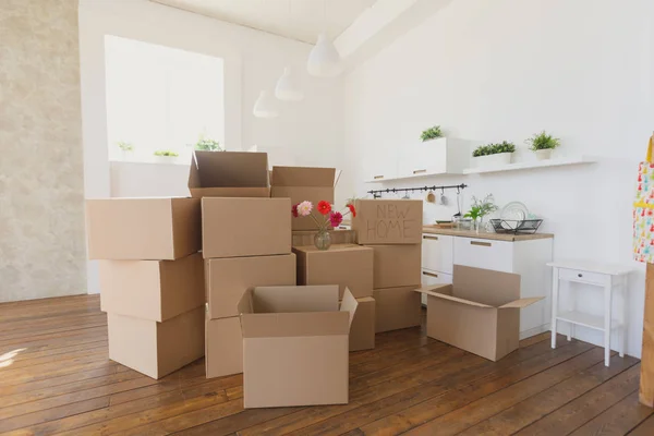 New home owners unpacking boxes, big cardboard boxes in new home. Moving to a new apartment concept