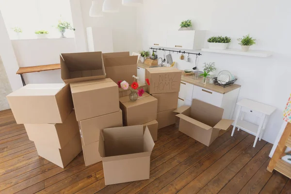 Desempacar cajas en un nuevo hogar y guardar cosas en la cocina, cajas de cartón grandes en un nuevo hogar. Mudarse a un nuevo concepto de apartamento —  Fotos de Stock