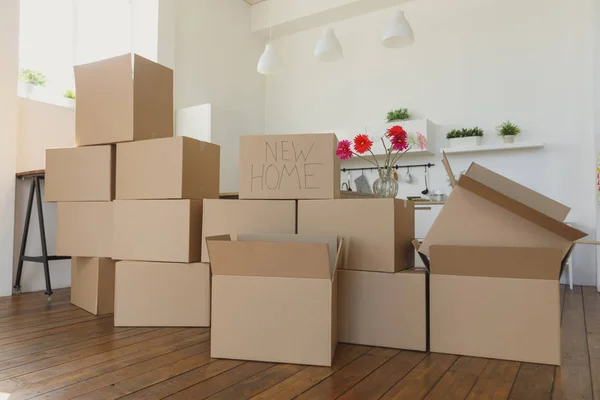 yeni ev kutuları açmak ve uzakta mutfak bir şeyler koyarak, yeni evinde büyük karton kutuları. Yeni bir daire kavram taşıma