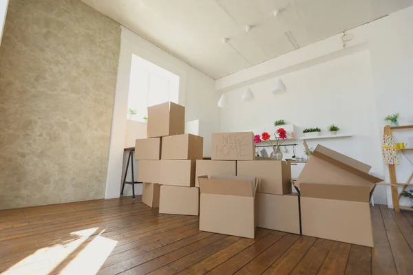 Desempacar cajas en un nuevo hogar y guardar cosas en la cocina, cajas de cartón grandes en un nuevo hogar. Mudarse a un nuevo concepto de apartamento —  Fotos de Stock