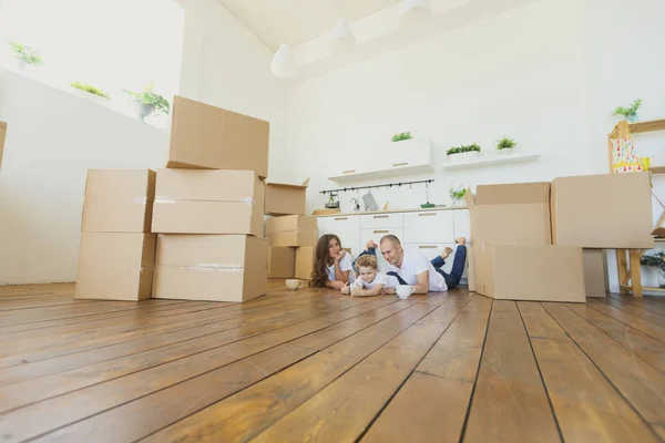 Trasferirsi in una nuova casa. Famiglia felice con scatole di cartone — Foto Stock