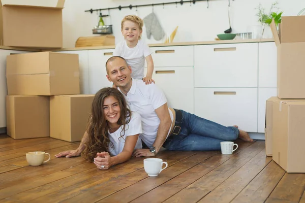 Felice famiglia che si trasferisce a casa con scatole intorno — Foto Stock