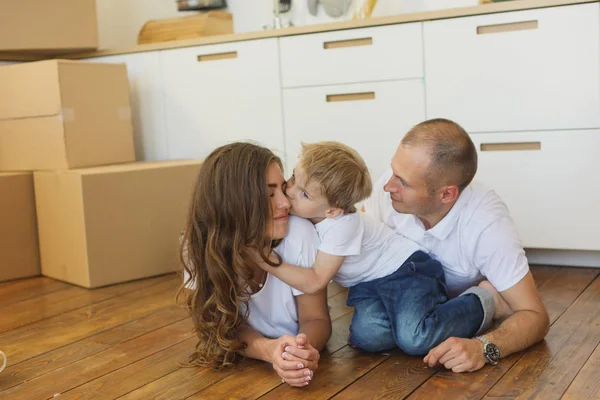 Familjen liggande på golvet av öppna lådor i nya hem leende — Stockfoto