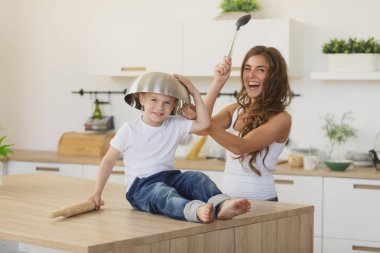 Cute preschooler and mum playing at kitchen clipart