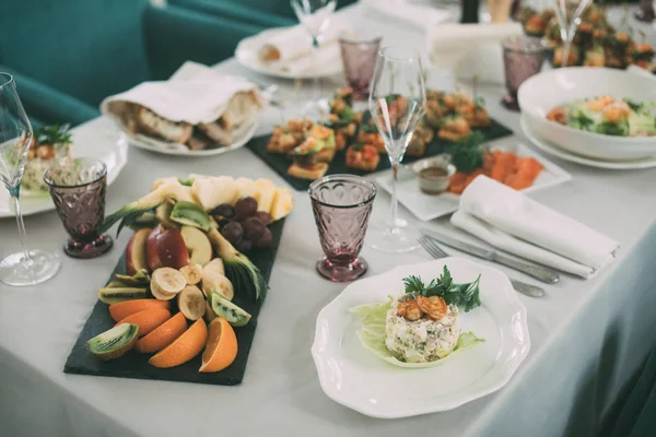 Deliziosa insalata sul tavolo con un bicchiere di vino — Foto Stock