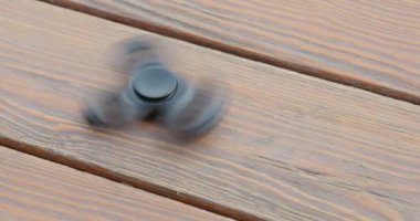 Yüksek hızda dönen el spinner veya topluca spinner ahşap arka plan üzerinde.