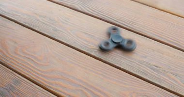 değer değişimi veya fidgeting spinner yere döner, el. ahşap arka plan.