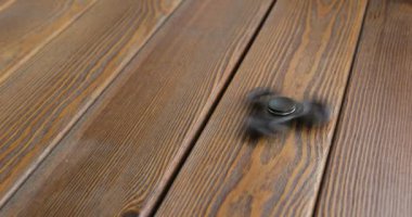 Yüksek hızda dönen el spinner veya topluca spinner ahşap arka plan üzerinde.