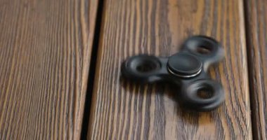 değer değişimi veya fidgeting spinner yere döner, el. ahşap arka plan.