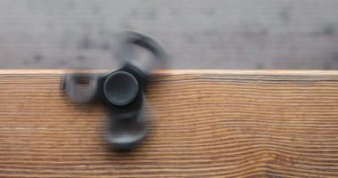 Yüksek hızda dönen el spinner veya topluca spinner ahşap arka plan üzerinde.