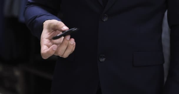 Stylish man in a suit jacket play with hand spinner. Close up — Stock Video