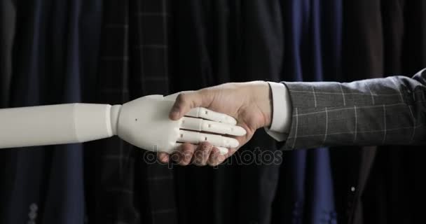 Moderní robotická technologie. Muž komunikuje s robotem, stiskne plastové mechanické rameno robota, handshake.