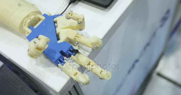 Ein Mensch und eine bionische Hand liegen nebeneinander. Ansicht von oben. Mann mit innovativem kybernetischen System heute. Drucken auf dem 3D-Drucker. Science-Fiction und Kunststoffprothesen. kybernetischer Roboterarm, der — Stockvideo