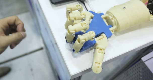 Ein Mensch und eine bionische Hand liegen nebeneinander. kybernetischer Roboterarm, der die Menschen kontrolliert. — Stockvideo