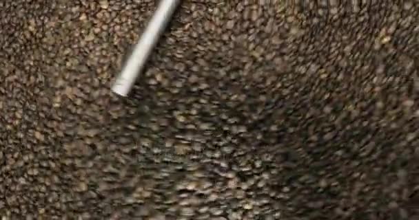 Asar granos de café remolino mezclado en la plataforma de la unidad de enfriamiento en un taller de fabricación, de cerca — Vídeo de stock