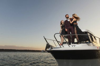 Grup genç arkadaş rahatlatıcı bir teknede, güneşli bir gün zevk