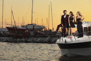 Grup genç arkadaş rahatlatıcı bir teknede, güneşli bir gün zevk