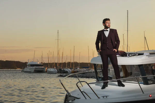 Homem em pé na frente do iate de luxo no mar. Bonito homem em uma regata . — Fotografia de Stock