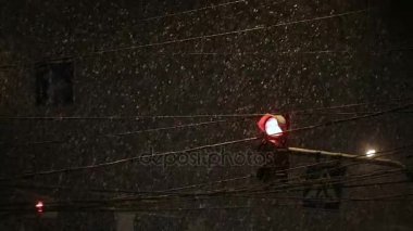 Kar yağışı sırasında parlayan ampul. Kötü hava, yağmur ve yolda ıslak kar. Yansımalar gece ışıkları. Araba farlar