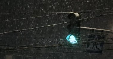 Kar yağışı sırasında parlayan ampul. Kötü hava, yağmur ve yolda ıslak kar. Yansımalar gece ışıkları. Araba farlar