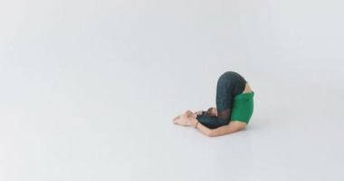 Kadın bir yoga egzersiz yapmak. Modern oda Yoga. Aydınlanma. Meditasyon. Manevi pratik. Manevi akıl hocası. Pencerenin önünde uzanan çekici genç kadın