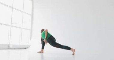 Kadın bir yoga egzersiz yapmak. Yogada ışık studio. Uyumlu insanlar. Barışçıl insanlar. İnsan vücudunun özellikleri.