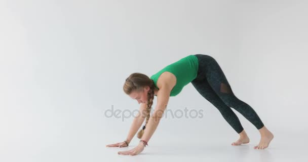 Donna che fa un esercizio di yoga. Yoga nello studio di luce. Persone armoniose. Persone pacifiche. Caratteristiche del corpo umano . — Video Stock