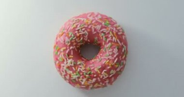 Parlak ve renkli serpilir çörek yakın çekim makro iplik beyaz bir arka plan üzerine vurdu. Lezzetli tatlı çörek bir plaka üzerinde döner. Üstten Görünüm