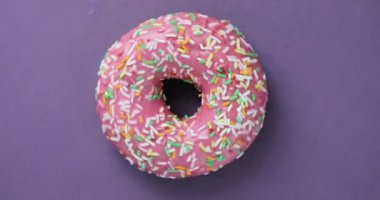 Parlak ve renkli serpilir çörek yakın çekim makro iplik mor bir arka plan üzerine vurdu. Lezzetli tatlı çörek bir plaka üzerinde döner. Üstten Görünüm