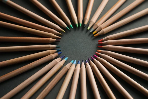 Color pencils in arrange in color wheel colors on black background — Stock Photo, Image