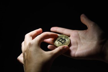 Altın Bitcoin siyah arka planda tutan kadının el