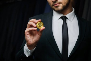 Altın Bitcoin siyah arka planda tutan el mans