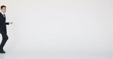 Çekici genç işadamı dansları hareket var. Beyaz arka plan