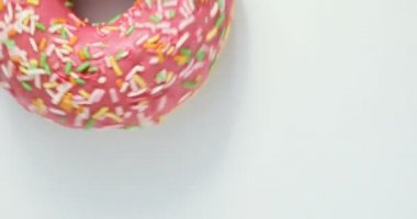 Parlak ve renkli serpilir çörek yakın çekim makro iplik beyaz bir arka plan üzerine vurdu. Lezzetli tatlı çörek bir plaka üzerinde döner. Üstten Görünüm