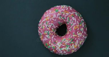 Parlak ve renkli serpilir çörek yakın çekim makro iplik bir siyah arka plan üzerine vurdu. Lezzetli tatlı çörek bir plaka üzerinde döner. Üstten Görünüm