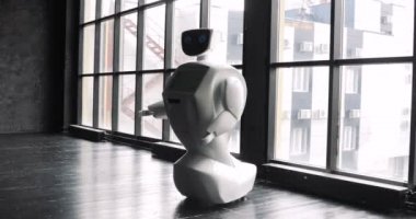 Pencerenin yanında insana ilişkin özerk robot. Robot duygular gösterir. Modern robotik teknolojiler