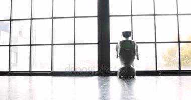 Pencerenin yanında insana ilişkin özerk robot. Robot duygular gösterir. Modern robotik teknolojiler