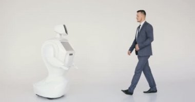 Şık bir adam bir robot ile iletişim kuran robot plastik mekanik bir kol presler el sıkışma. Sibernetik sistem bugün. Modern robotik teknolojiler. Özerk insansı robot.