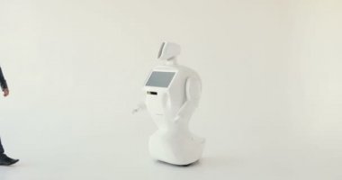 Şık bir adam bir robot ile iletişim kuran robot plastik mekanik bir kol presler el sıkışma. Sibernetik sistem bugün. Modern robotik teknolojiler. Özerk insansı robot. Beyaz arka plan