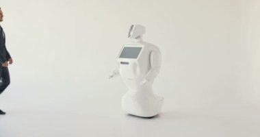Şık bir adam bir robot ile iletişim kuran robot plastik mekanik bir kol presler el sıkışma. Sibernetik sistem bugün. Modern robotik teknolojiler. Özerk insansı robot. Beyaz arka plan