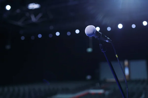 Microfone na sala de concertos ou sala de conferências com luzes frias no fundo . — Fotografia de Stock