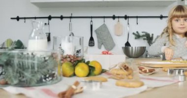 Küçük kız pişirme. Küçük kız eğleniyor ahşap masa üzerinde hamur ile oynarken