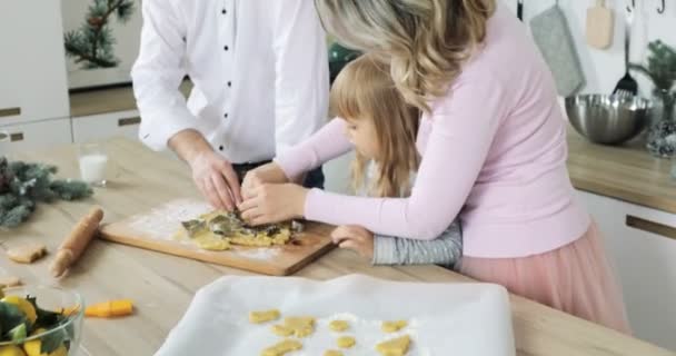 Familia preparando pan de jengibre de Navidad en la cocina. linda hija pequeña preparar galletas de Navidad — Vídeos de Stock